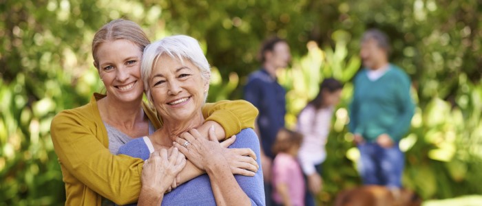 mother and adult daughter hugging and smiling