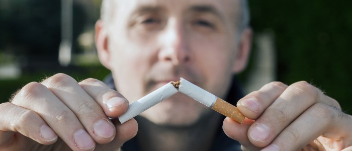 man holding a snapped cigarette