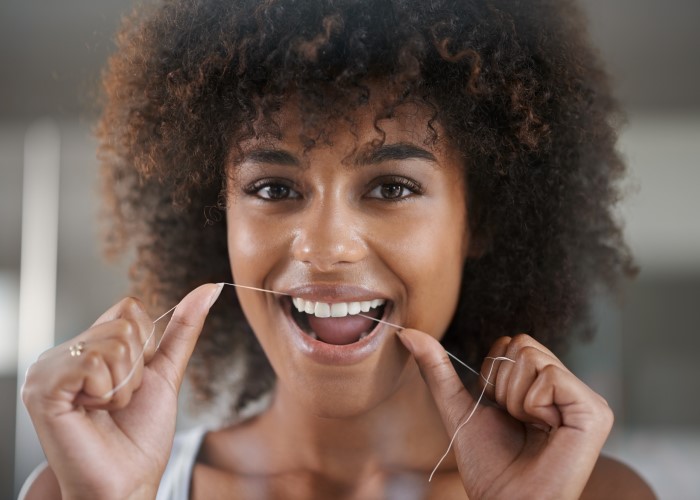 woman flossing with dental inlays and onlays